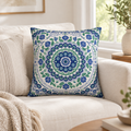 Mandala cushion in cobalt blue, green and white folk print on a cream sofa